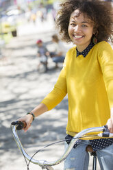 Porträt lächelnde Frau auf Fahrrad im Park - CAIF12183