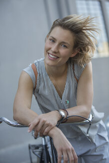 Porträt lächelnde blonde Frau auf Fahrrad - CAIF12201