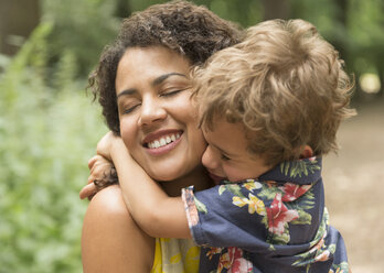 Close up affectionate mother and son hugging with eyes closed - CAIF12280