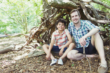 Portrait lächelnder Vater und Sohn im Wald - CAIF12285