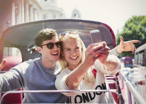 Pärchen macht Selfie im Doppeldeckerbus in London, lizenzfreies Stockfoto