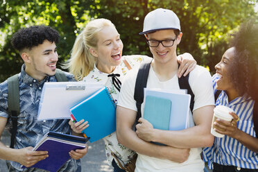 Enthusiastische Studenten scherzen draußen mit ihren Freunden - CAIF12344