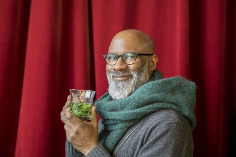 Porträt eines glücklichen Mannes mit einem Glas Tee, lizenzfreies Stockfoto