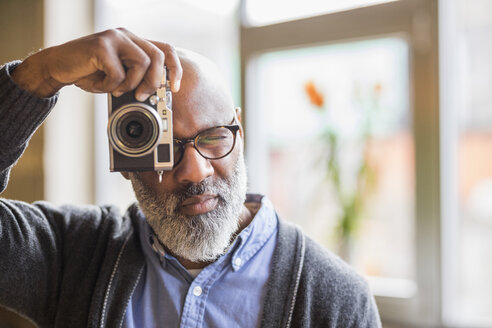 Portrait ofman taking photo with camera - FMKF04913