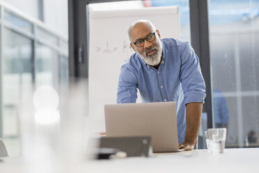 Portrait of businessman in conference room leading a presentation - FMKF04925