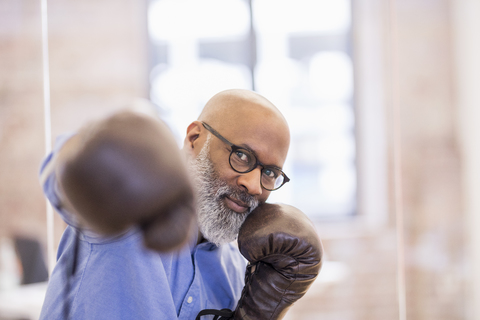 Portrait of businessman with boxing gloves stock photo