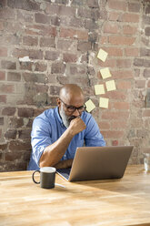 Businessman using laptop in the office - FMKF04945