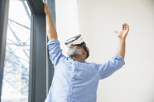 Geschäftsmann mit VR-Brille am Fenster - FMKF04962