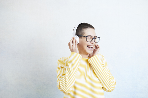 Glückliche junge Frau, die mit Kopfhörern Musik hört, lizenzfreies Stockfoto
