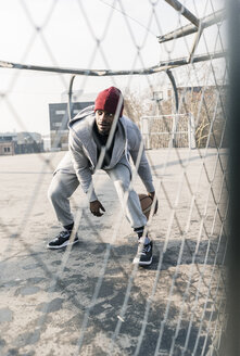 Basketballspieler in Aktion auf dem Platz hinter dem Zaun - UUF13009