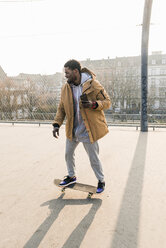 Junger Mann auf Skateboard auf dem Platz - UUF13032