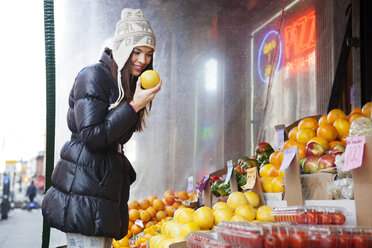 Seitenansicht einer Frau, die an einem Marktstand Obst einkauft - CAVF05596