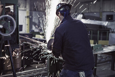 Rückansicht eines Arbeiters beim Schweißen in einer Fabrik - CAVF05698