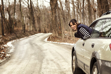 Porträt einer glücklichen Frau, die aus dem Auto blickt - CAVF05734