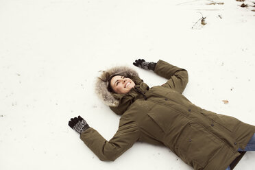 Hohe Winkel Ansicht der glücklichen Frau auf Schneefeld liegend - CAVF05738