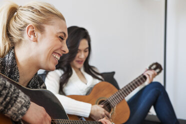 Friends practicing guitar at home - CAVF05839