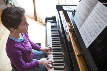 Girl practicing piano at home - CAVF05919