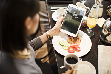 Hohe Winkel Ansicht der Frau mit Tablet-Computer beim Sitzen am Tisch im Restaurant - CAVF05938