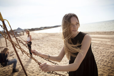 Friends enjoying on swing at beach - CAVF06046