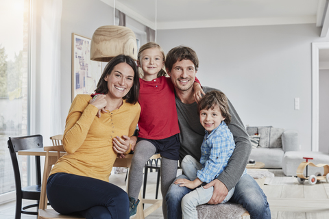 Porträt einer glücklichen Familie mit zwei Kindern zu Hause, lizenzfreies Stockfoto
