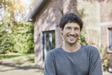 Portrait of smiling man in front of his home - RORF01189