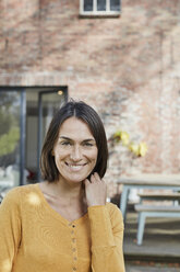 Portrait of smiling woman in front of her home - RORF01192