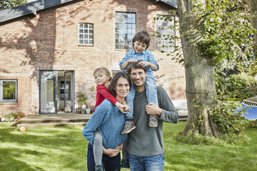 Portrait of happy family in garden of their home - RORF01228