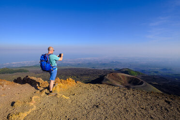 Italy, Sicily, Mount Etna, hiker photographing crater - LBF01849