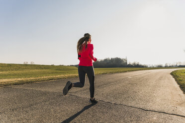 Young woman running on country road - UUF13048