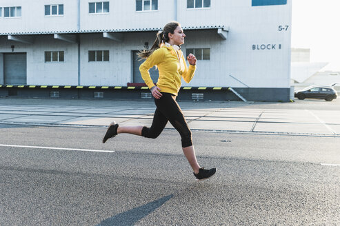 Young woman running on a street - UUF13074