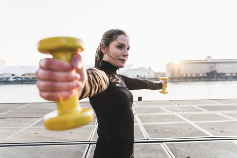 Junge Frau beim Sport in der Stadt bei Sonnenuntergang, lizenzfreies Stockfoto