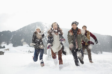 Happy friends playing in snowy field - CAIF12346