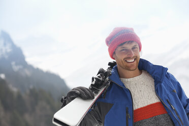 Porträt eines lächelnden Mannes mit Skiern - CAIF12351
