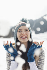 Happy woman watching snow fall - CAIF12353