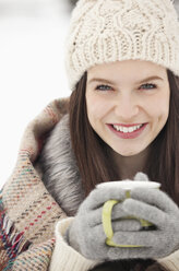 Close up portrait of woman in knit hat and gloves drinking coffee - CAIF12361