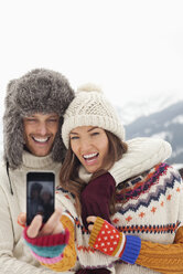 Enthusiastic couple taking self-portrait with camera phone - CAIF12380