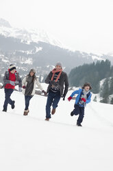 Happy family running in snowy field - CAIF12389