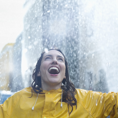Enthusiastic woman standing in rain stock photo
