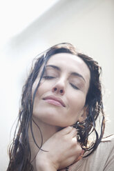 Nahaufnahme eines Porträts einer ruhigen Frau mit nassen Haaren - CAIF12445