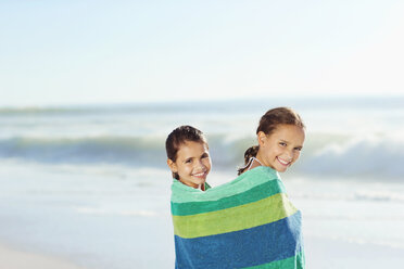 Mädchen in Handtuch eingewickelt am Strand - CAIF12455