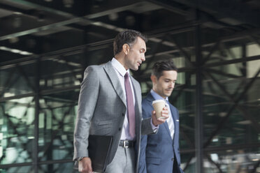 Geschäftsleute mit Kaffee im Gespräch und beim Gehen - CAIF12475