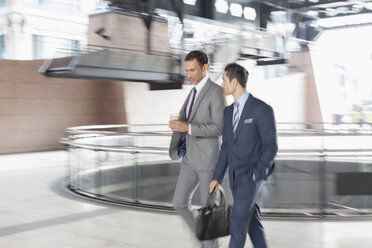 Corporate businessmen with coffee walking and talking - CAIF12478