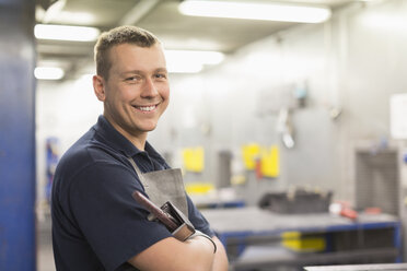 Porträt eines lächelnden Arbeiters in einer Stahlfabrik - CAIF12488