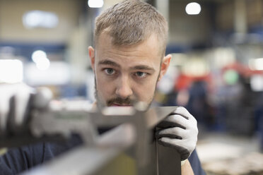 Konzentrierter Arbeiter bei der Prüfung eines Teils in einer Stahlfabrik - CAIF12501