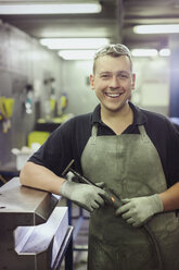 Porträt eines lächelnden Arbeiters in einer Stahlfabrik - CAIF12512