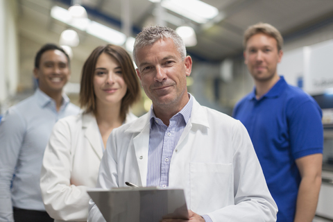 Porträt eines lächelnden Ingenieurteams in einer Stahlfabrik, lizenzfreies Stockfoto