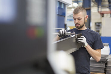 Arbeiter misst Stahl mit einem Messschieber in einem Stahlwerk - CAIF12567