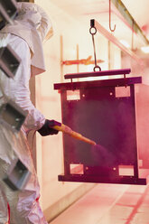 Arbeiter streicht Stahl rot in einer Stahlfabrik - CAIF12583