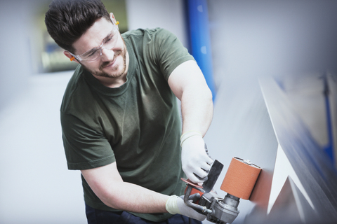 Arbeiter beim Schleifen von Stahl in einer Stahlfabrik, lizenzfreies Stockfoto