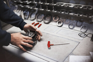 Arbeiter beim Zusammenbau eines Teils in einer Stahlfabrik - CAIF12605